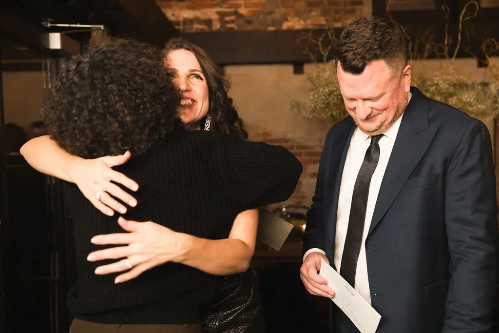 Charity sharing an emotional hug with a newlywed